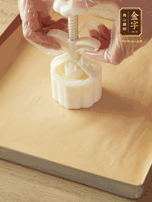 取一個(gè)面團(tuán)，捏扁，中間厚，四周薄。虎口往上推，直到收口，把餅胚放入模具里，壓2-3下