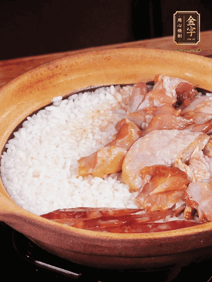 煮到椰子水微微收干轉(zhuǎn)小火，快速均勻鋪上雞肉、金字香腸